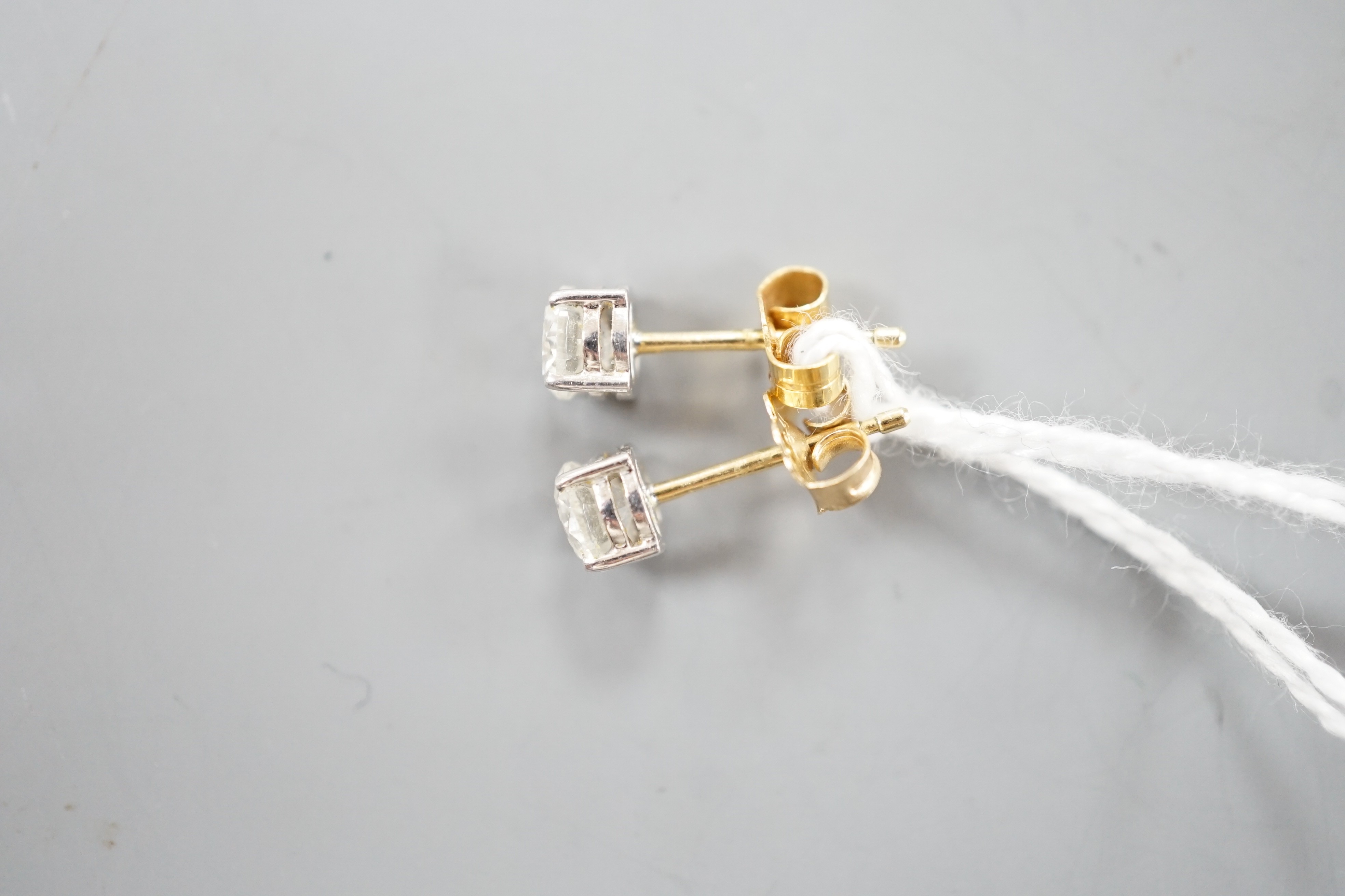 A pair of 18ct gold and solitaire diamond set ear studs, stone diameter approx. 4.8mm, gross weight 1.2 grams.